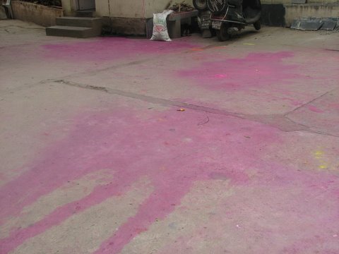 pink stains in driveway of apt building after Holi 230308