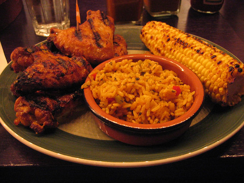 Chicken wings with Peri Peri sauce, spicy rice and corn on the cob