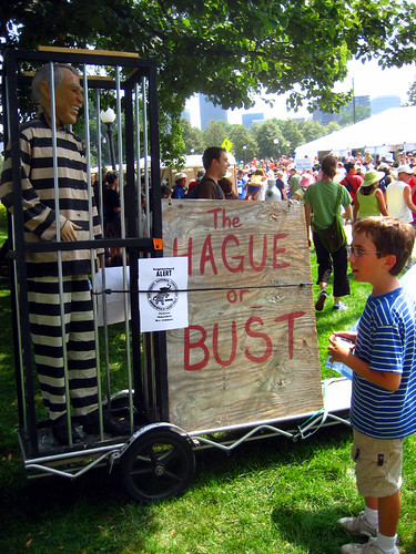 Young boy looks at puppet Bush in jail for war crimes