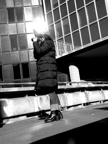 Photographe au pied des tours de l'esplanade de la Défense (Paris)