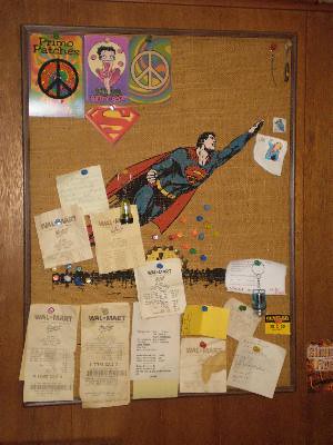My Superman bulletin board full of receipts and other items including Supergirl stamp