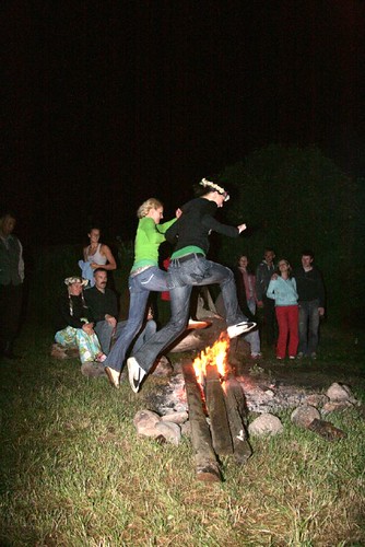 Zwei Frauen springen über ein Lagerfeuer