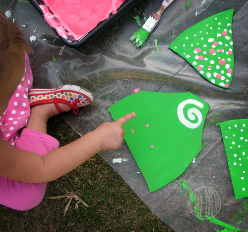 child adding paint sprinkles to cardboard pieces