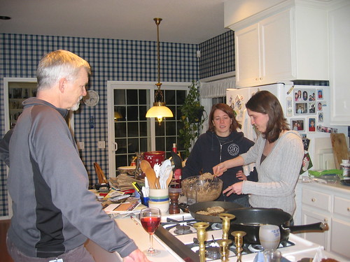 Rebecca cooking latkes; Fitz and Jessica supervising