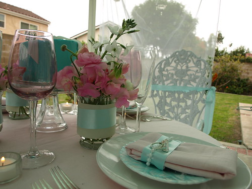Glass containers covered with ivory vellum and Tiffany blue ribbon were 