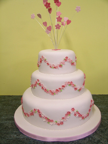 Pink and white wedding cake with hearts and flowers starbursts