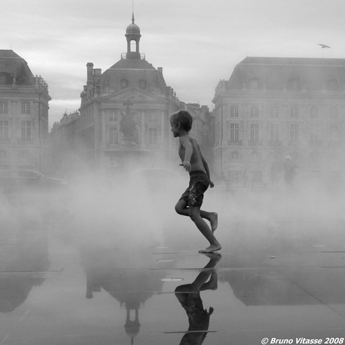 Enfant courant dans la brume du miroir d'eau (Bordeaux)