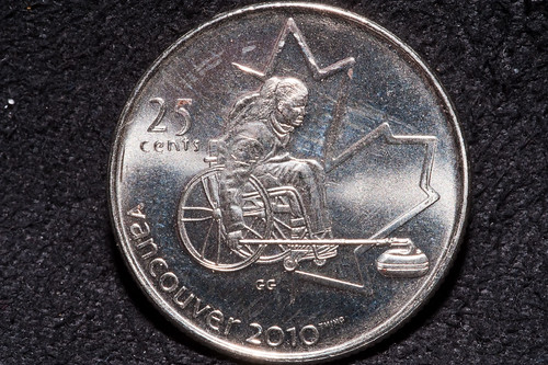 A Canadian quarter (25 cents) showing a woman using a wheelchair for curling