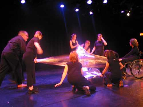 dancers holding shiny sheets of fabric