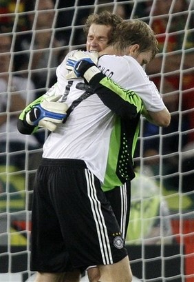 Jens Lehmann hugs his teammate Per Mertesacker after the quarterfinal match