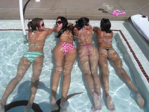 Bikini girls cooling off in a swimming pool
