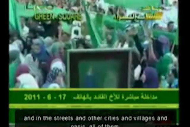 Screenshot @ 0:04:57 Speech_Gaddafi_June_17_2011_English_subtitles_during_mass_demonstration_in_Tripoli-Rt3l_dm0zhE