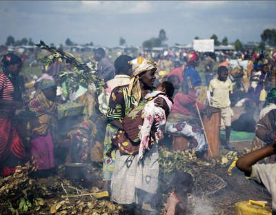 A group of Congolese displaced cook as they stay in an improvised camp in Kibati