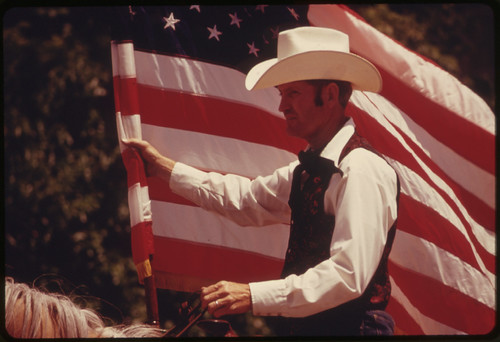 Rider with an American Flag on Horseback in a Parade on the Main Street of Cottonwood Falls, Kansas, near Emporia...06/1974