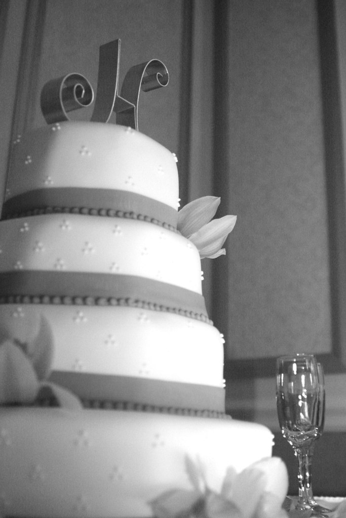 chic modern four tiered wedding cake and champagne glasses at reception
