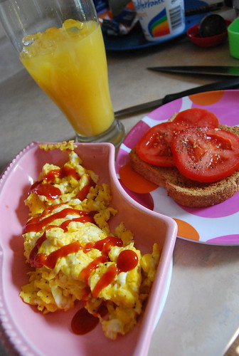 Scrambled eggs, toast with tomato, OJ on ice