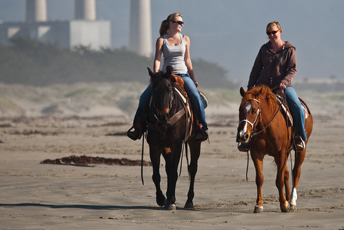 1 of 2 Two female equestrians enjoy a slow ride on their beautiful horses on Morro Strand State Beach, 06 April 2009