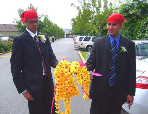 Two best boys holding Sikh wedding flowers at Akali Singh Sikh Temple in