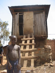 Boy in front of typical Pit latrine in Kampala slums