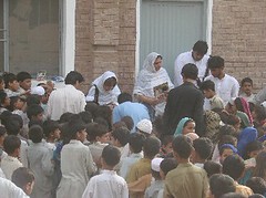 Ghazala Minallah and Naila Zahid distributing coloured books and pencils