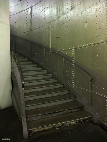 Escaliers en métal, montant le long des plaques rivetées