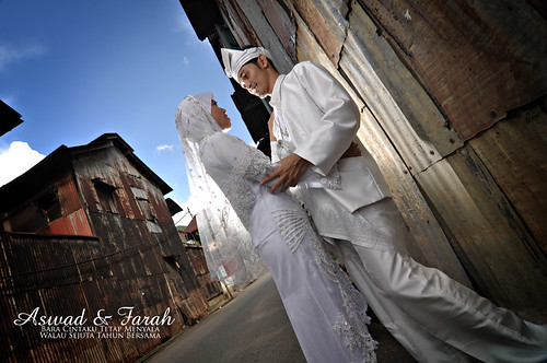 Aswad & Farah, poses in front of a rusted zink wall in Sungai Lembing. Shot by tom ramzul