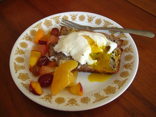 poached egg over banana bread with fruit salad
