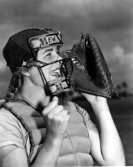 Dottie Schroeder, catcher, shouting play ball behind mask