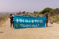 Choi Sung Hee拉著抗議布條，布條上寫著：不要碰這裡的一顆石頭，一朵花！