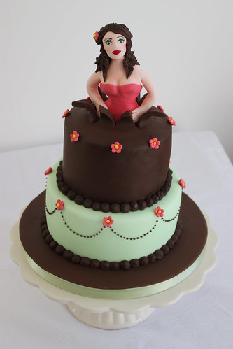 woman jumping out of birthday cake