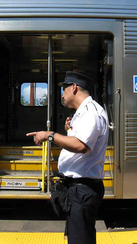 Metra commuter train conductor talking to the locomotive engineer via two way radio. Northbrook Illinois. June 2009.