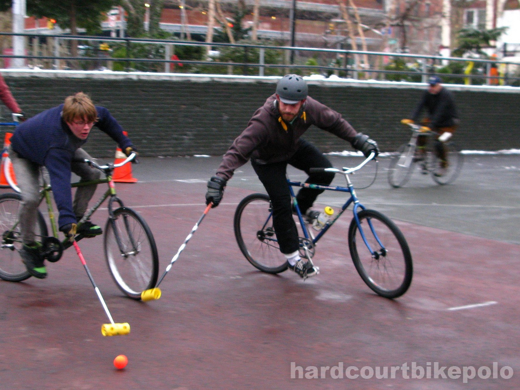 Hardcourt Bike Polo Lief and Paul reaching for ball