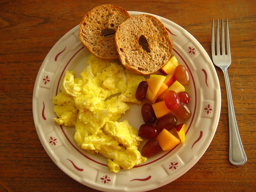 scrambled eggs, bagel, fruit salad