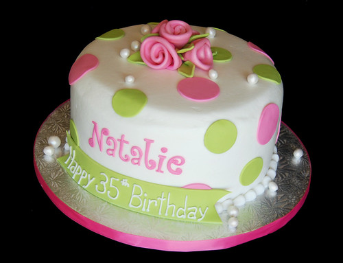pink and green polka dot birthday cake with ribbon roses and pearls