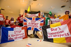 Anti-aviation campaigners with the flags of the other protesting nations join together at Heathrow Terminal One to demonstrate against the 3rd runway and aviation expansion. by Euroflashmob Heathrow and Europe