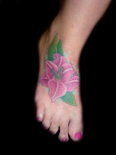 hibiscus flower tattoos. lilly flower tattoo on foot.