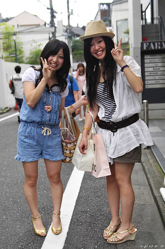 Two Japanese girls smiling for a street fashion photo in Harajuku