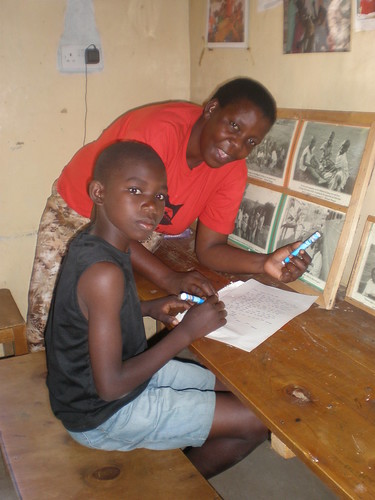 composing letter. Ruth Adhiambo and student composing a letter to a donor