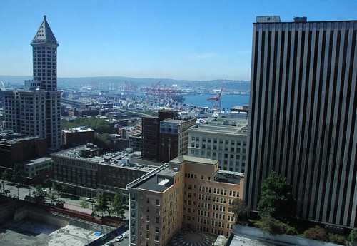 Smith Tower, skyscrapers, and a view of the Port of Seattle, orange cranes, on a sunny day, from the Columbia Tower, Seattle, Washington, USA by Wonderlane