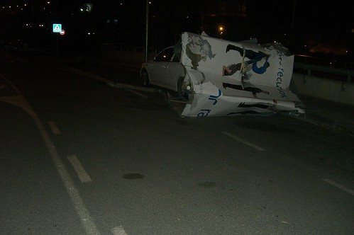 imagen foto de panel publicidad acartonado por el golpe del viento contra un coche en Esplugues