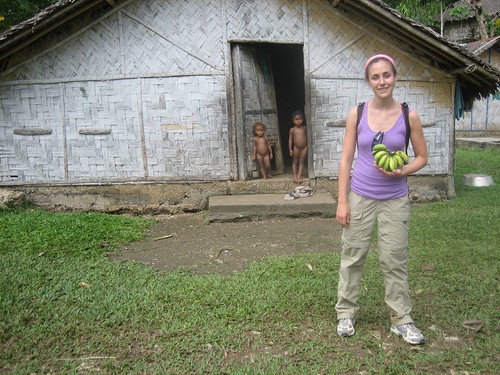 Hannah with bananas and naked little girls peering out of their house