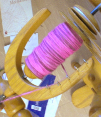 Full spinning wheel bobbin of pink Rambouillet handspun wool yarn