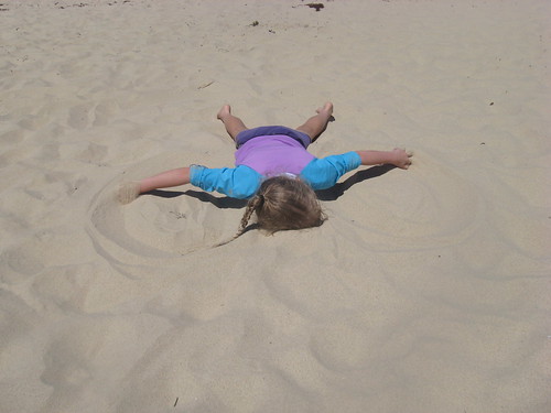 Caitlin making sand angels
