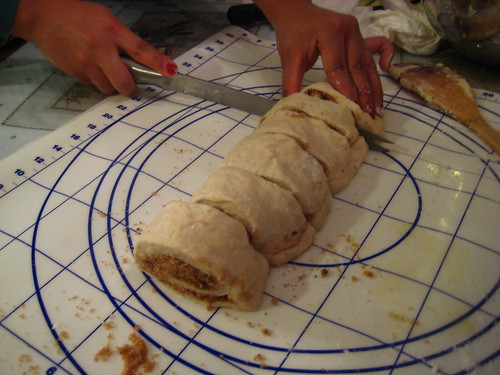 slicing the cinnamon roll.