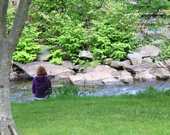 Woman sitting by river