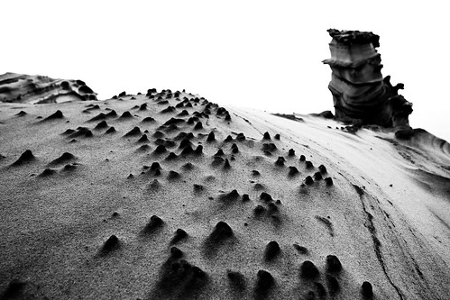 奇岩。黑白處理過的照片，很多人在沙漠中看著霜淇淋