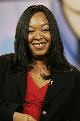 Shonda Rhimes, a Black woman seated at an interview. She is smiling broadly for the camera.