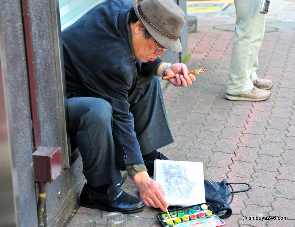 Going about the work of painting without noticing people around him.