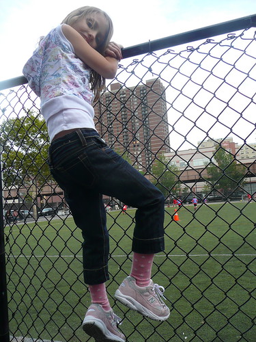 climbing the fence while bain plays soccer.