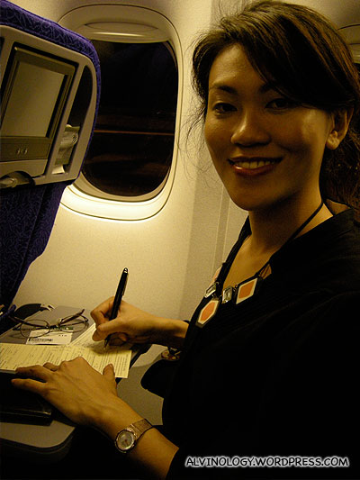 Rachel writing her diary while on board our SQ flight
